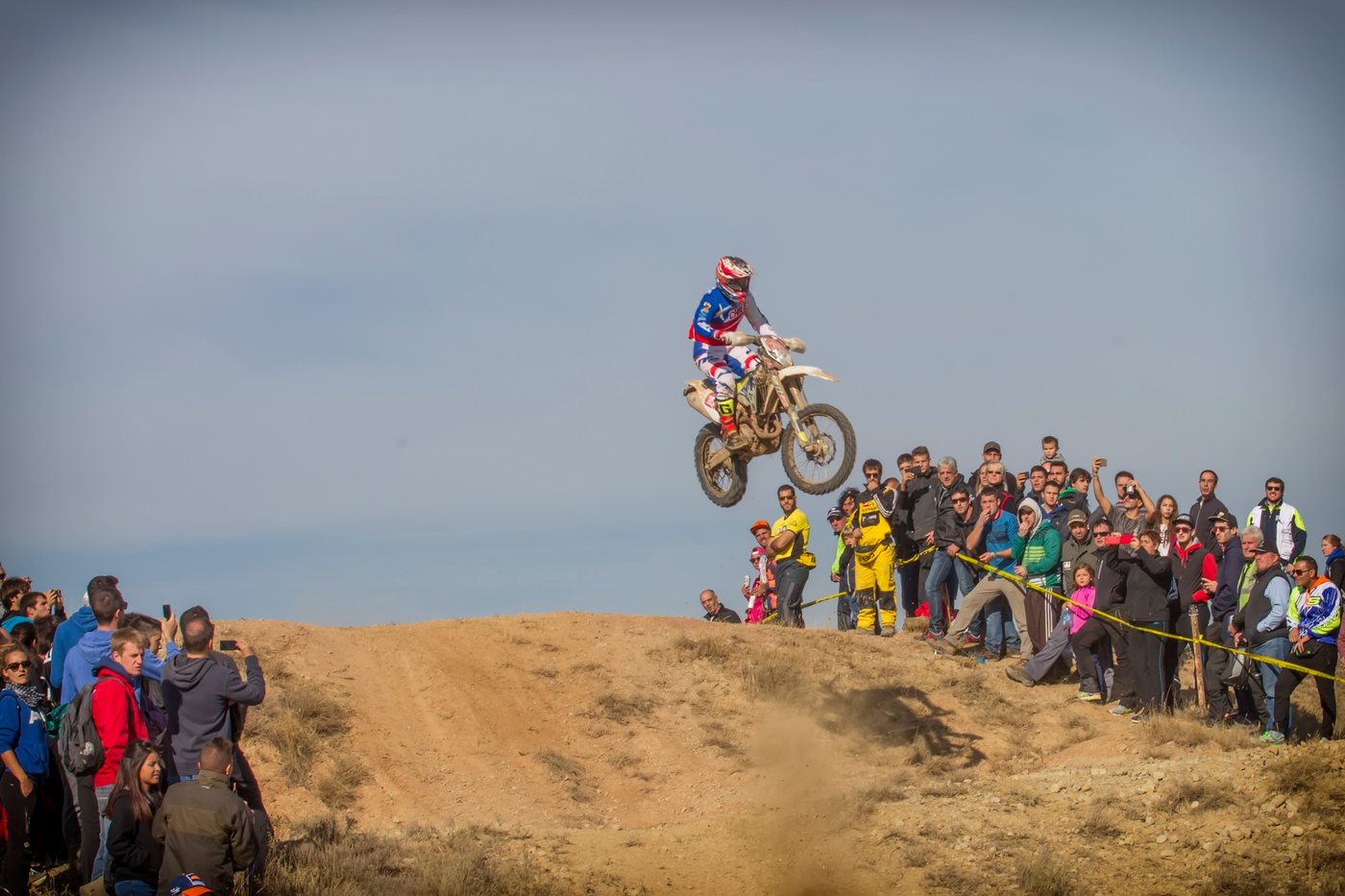 Piloto con los colores de Chile en pleno salto durante una carrera de enduro