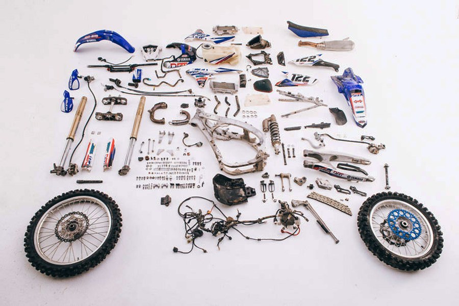 Todas las piezas de una moto de motocross desarmadas y ordenadas sobre una mesa